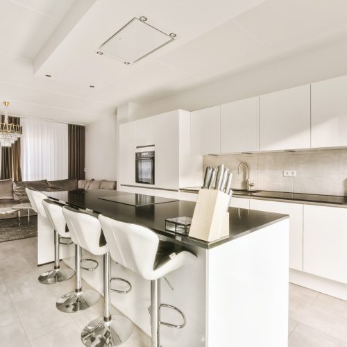 a kitchen with white cabinets and a black counter top
